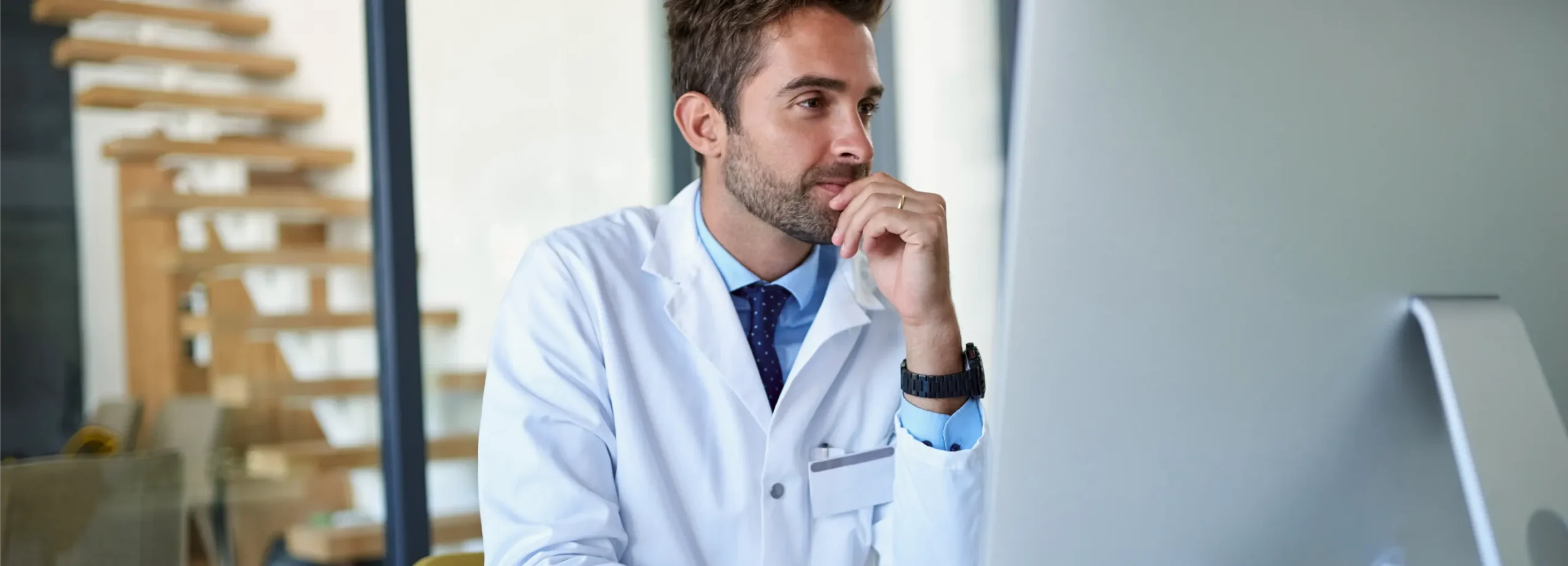 Healthcare provider reviewing practice data and workflows on a computer to improve operational performance and patient growth