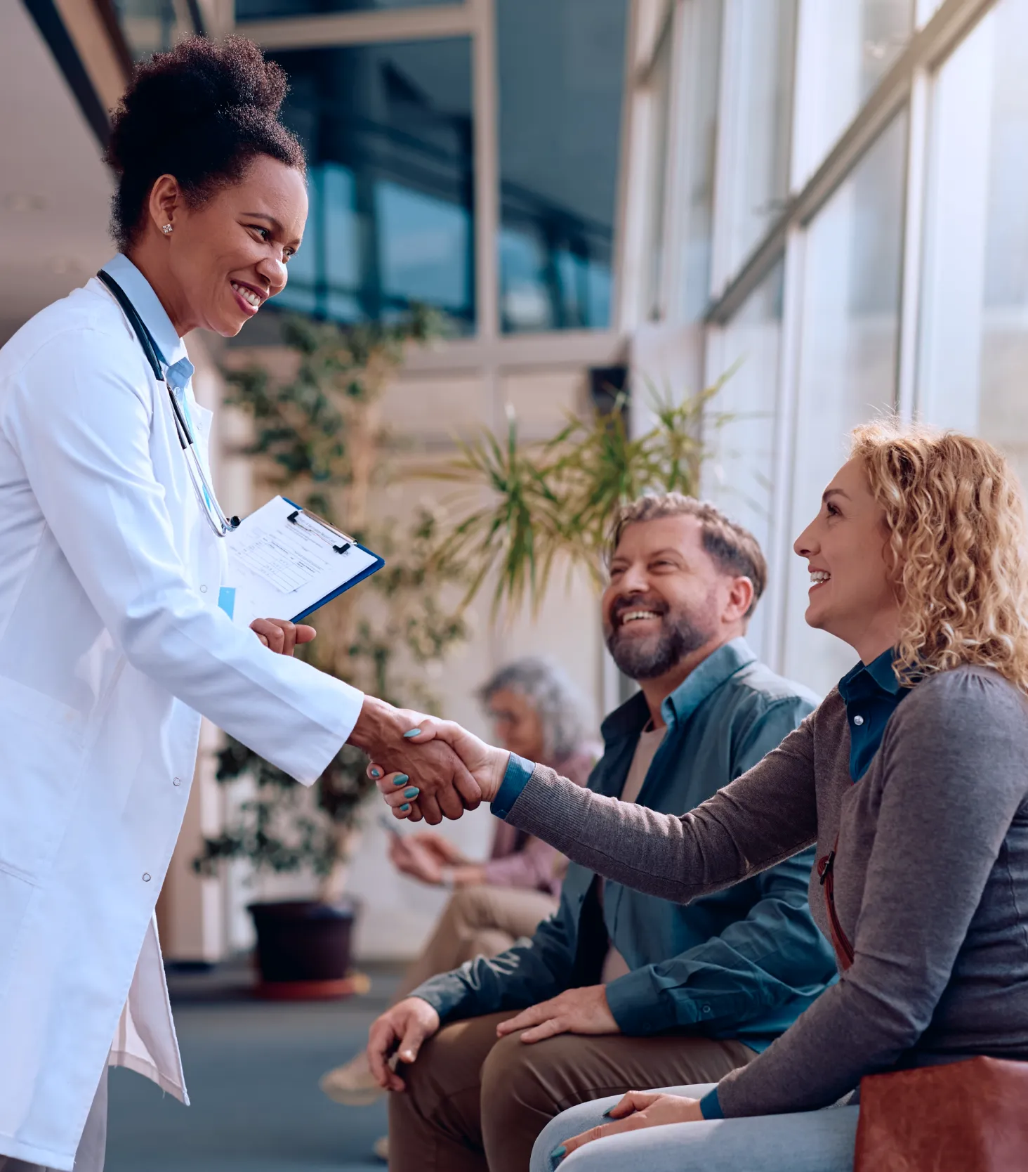 Physician greeting patients in a medical practice waiting room, demonstrating compassionate healthcare and patient-centered care.