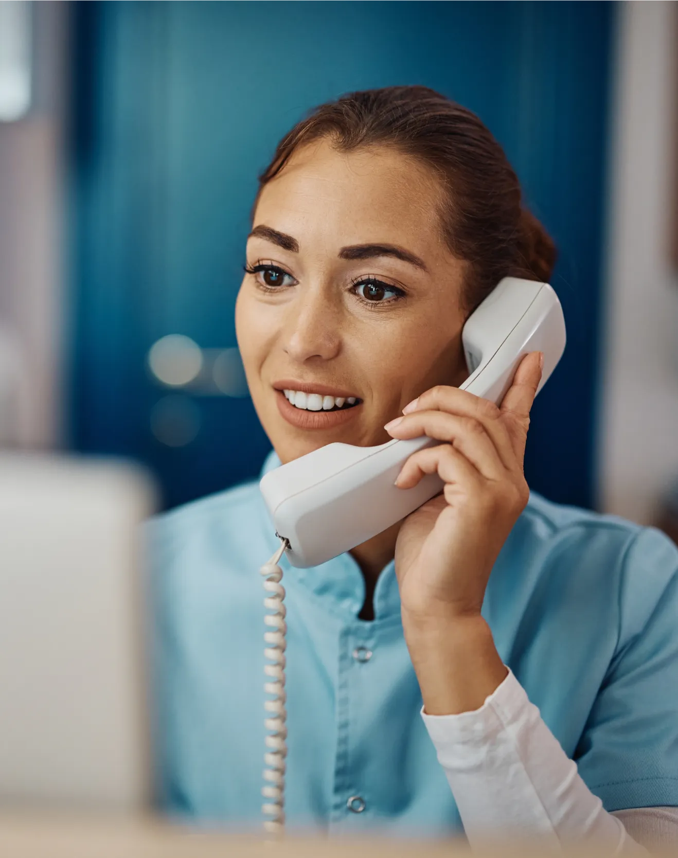 Healthcare staff member speaking with a patient by phone to schedule follow-up care and support patient recall efforts